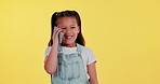 Happy, phone call and child in studio talking for online chatting, speaking and contact. Smile, youth and young girl on smartphone for communication, networking and conversation on yellow background