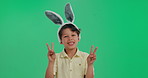 Portrait, peace sign and child in studio with bunny ears for care, playful character and easter celebration, Fun, happy face and boy in rabbit costume for respect, holiday or kid on green background