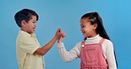 Handshake, pinky promise and face of children in studio for friendship, connection and bonding. Happy, youth and boy and girl holding fingers for love, affection and secret on blue background