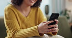 Woman, hands and typing with phone on sofa for online chatting, texting or app at home. Closeup of female person with smile on mobile smartphone for browsing, research or news in living room at house