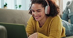 Girl, laptop and headphones on couch in home with smile, listen and relax with subscription in living room. Woman, person and happy on computer, streaming or search for song at apartment in Colombia