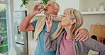 Senior couple, smoothie and smile in kitchen with toast for workout, wellness and supplements in home. People, woman and man with protein, milkshake and drink for benefits, hug and fitness in house