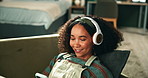 Happy woman, relax and sofa with headphones for music, playlist or audio on phone at home. Young female person lying on couch or enjoying album or podcast with headset on mobile smartphone at house