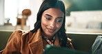 Woman, tablet and relax on sofa in home with reading, notification or happy for post on web. Indian person, digital touchscreen and smile for scroll, thinking or search on internet on couch in Mumbai