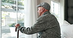 Senior man, cane and thinking in home with grief, memory and depression on bed by window in retirement. Elderly person, lonely and sad in house bedroom with alzheimer, arthritis and walking stick