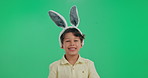 Portrait, smile and child in studio with bunny ears for fantasy, playful character and easter celebration, Fun, happy face and boy in rabbit costume for halloween, holiday or kid on green background