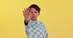 Young boy, face and stop in dungaree on studio background for warning, protest and wrong action. Child, portrait and palm with upset, frustrated and problem for communication, opinion and decision