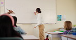 Woman, math and writing on whiteboard in classroom for learning, development and students growth. Teacher, curriculum and children in kindergarten or elementary school for knowledge, study and test