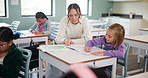 Teacher, woman and help kid for writing, studying and education in notebook at classroom. Child, educator and student learning in lesson for development, teaching and support in elementary school