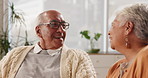 Senior couple, laugh and speaking in house with love in retirement for marriage, happiness and funny. Elderly people, joke and smile on sofa in living room with care, support and trust for bonding