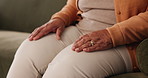Hands, anxiety and senior woman on sofa nervous for diagnosis of parkinsons or dementia at home. Scared, waiting and mature female person with concern for medical results in living room at house.