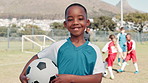 Boy, face and training with smile, soccer and ball with pride, learning or outdoor for development. Child, excited and football team with portrait, exercise and happy with fitness on grass field