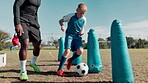 Boy, ball and training for soccer with coach on field with kick, inflatable and running with fitness. Football club, child and skill for match workout, drill and player on grass for sport or exercise