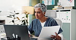 Woman, nurse and documents with laptop in office for healthcare research, reading information and schedule surgery. Mature, doctor and digital for Telehealth, history record and results at clinic