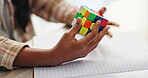 Color, cube and puzzle on hands, kid and closeup of student in classroom with notebook and desk. Middle school, growth and development of child with challenge of pattern, solving and goal for game