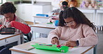 Student, desk and girl with test in classroom, homework or quiz activity for young learner. Education, childhood development and information, knowledge and female person in junior school for studying