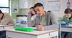 Boy, stress and writing test in classroom with thinking, remember and confused by question in paper. Student, teenager and high school kids with anxiety, mistake or brain fog in assessment at academy