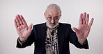 Stop, senior man and portrait in studio with hands up, conflict and instruction on white background. Elderly male person, hand gesture and command with mockup for opinion, defense sign and caution