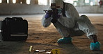 Forensic photographer, crime scene and person with evidence for investigation, inspection and observation. Hazmat suit, police marker and investigator with camera for clues, criminal dna and proof