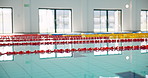 Indoor, empty and swimming pool for sport, health and professional competition with lane lines. Training arena, window reflection and water for aquatic activity with exercise, workout and wellness