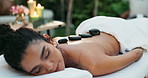 Calm woman, relax and rocks with back massage at beauty spa for stress relief on bed at outdoor resort. Closeup of young female person lying on table in relaxation for therapy treatment at salon