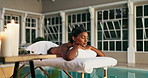 Hotel, peace and woman with massage on table for treatment, hospitality and spa service. Zen, female client and relax with aromatherapy by pool for candle scent, holistic healing or support in health