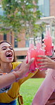 Woman, cheers and friends outdoor on campus for picnic, diet and happy for hydration at college. University student, drink and toast in park or garden with gen z people on lawn for lunch break