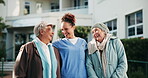 Happy, hug and senior women with caregiver outdoor in retirement community with daily assistance and support. Elderly people, nurse and bonding with laugh, trust and wellness by residential care home