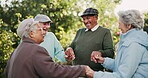 Friends, holding hands and laughing with old people in garden together for bonding, fun or retirement. Comedy, funny or smile with elderly men and woman in circle at park for humor or wellness