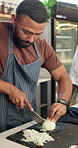 Man, cooking and master class as student with slicing onions in restaurant for diet, nutrition and food. Male person, culinary arts and gourmet cuisine with chef, menu and skills in kitchen as cook