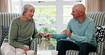 Conversation, holding hands and love with old couple eating biscuits in living room of home together. Relax, retirement or smile with senior man and woman in apartment for bonding, rest or tea break