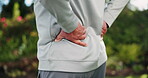 Senior man, exercise and hands with back pain in nature for muscle strain, inflammation and cramp. Outdoor, fitness and body or person with workout injury for arthritis, tension and accident in park