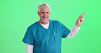 Face, man and doctor with pointing, green screen and professional on studio background. Portrait, person and model with hand gesture, medical and professional in uniform, healthcare and presentation