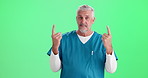 Face, man and doctor with pointing up, green screen and professional on studio background. Portrait, person and model with hand gesture, medical and professional in uniform, healthcare and promotion