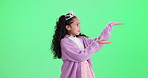 Presentation, tiara and face of child on green screen for promotion, bargain and discount news. Princess, fashion and portrait of isolated young girl with hand gesture for announcement on chromakey