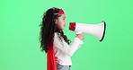 Child, girl and bullhorn for speech in studio profile with superhero costume by green screen background. Kid, megaphone and noise with sound, announcement and power for justice, action and stop crime