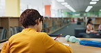 Boy, writing and studying with book in library for education, learning or literature at school. Back view of young male person, teenager or child taking notes for exam, test or paper at bookstore