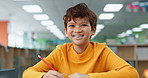 Boy, education and happy at library in school with notebook for assessment or assignment. Kid, studying and smile or proud on portrait with stationery for child growth and brain development
