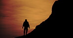 Man, hiking and orange sky with nature shadow, silhouette and adventurer for fitness with backpack. Active, challenge and sunset for wellness, exercise and calm or peaceful on rocks with horizon