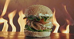 Breakfast burger, flame and serving with fast food in restaurant for hospitality or take away order. Bacon, cheese and egg with sandwich for cooking, eating or gourmet meal on wooden table in cafe