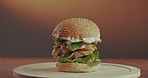 Beef, burger and vegetables with spin table for tasty meal, lunch or fast food on a studio background. Closeup of bread or bun rotating with mixed ingredients or stack for snack or cooked dinner