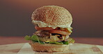 Breakfast burger, stack and time lapse with fast food in restaurant for hospitality or take away order. Bacon, cheese and egg with bun for cooking, eating or gourmet meal on wooden table in cafe