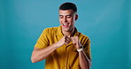 Man, joy and dancing to music in studio with fun energy and happiness. Smile, celebration and dancer person streaming and listening rap, hip hop or audio subscription on blue background to relax