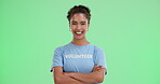 Volunteer, woman and happy in green screen with arms crossed for love, support and care. Portrait, studio and smile or exited with confident on community service or charity for change, trust and NGO