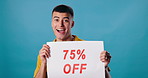 Poster, discount and face of man on blue background for 75 percent promotion, information and sign. Happy, advertising and portrait of person with banner for retail sale, deal and bargain in studio