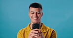 Happy man, phone and laughing for funny joke, social media or meme on blue studio background. Male student, guy and smile on mobile smartphone for fun research, chatting or texting on mockup