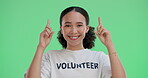 Volunteer, face and woman on green screen pointing for information, website details or choice in studio. Help, NGO and person with gesture for decision, charity donation or community development