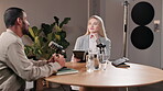 Podcast, meeting and people with mic in discussion for interview, recording and guest on talk show. News, information and host with tablet at desk for broadcast, live streaming and content creation