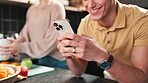 Phone, couple and hands of happy man in kitchen while cooking lunch together with woman. Mobile, reading and app for recipe, dinner blog and scroll food tutorial for healthy diet on internet in home