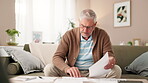 Senior man, home and stress with documents in living room for finances on water or electricity bills. Male person, sofa and disappointed with compare invoice for bank loan, mortgage and interest rate